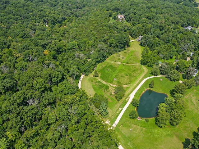 aerial view of property's location with a large body of water and a heavily wooded area