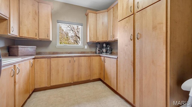 kitchen featuring light brown cabinets and light countertops