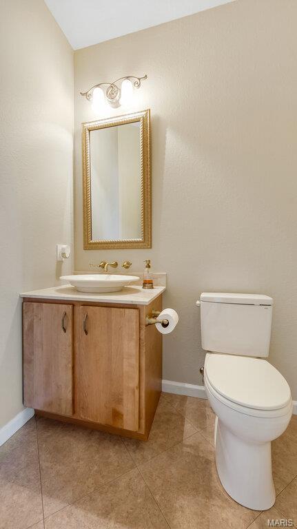 bathroom with tile patterned floors, toilet, vanity, and baseboards