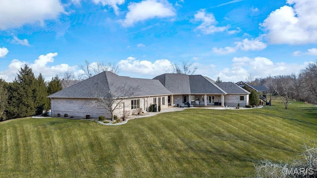 rear view of house with a yard and a patio area