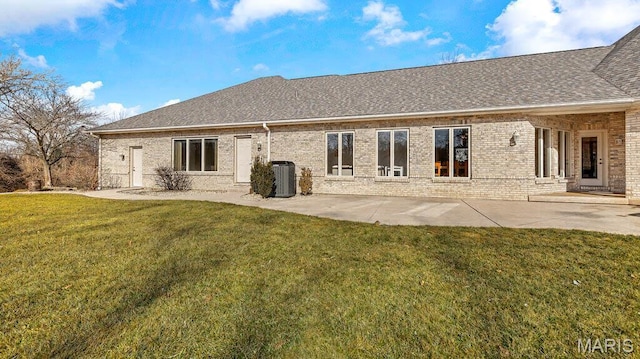 back of property with a lawn, central AC, brick siding, and roof with shingles
