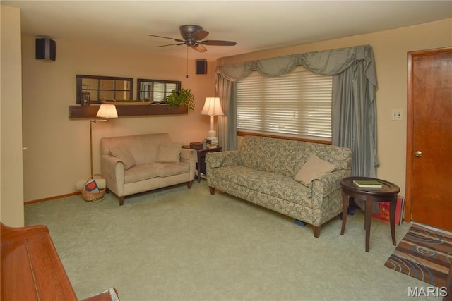 living area with a ceiling fan, carpet floors, and baseboards