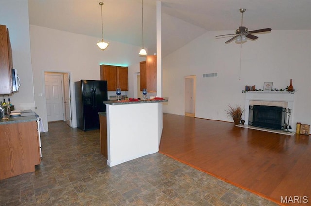936 Palamino Path, High Ridge, MO 63049 - kitchen with stainless steel appliances, high vaulted ceiling, brown cabinetry, ceiling fan, and open floor plan