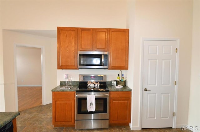 936 Palamino Path, High Ridge, MO 63049 - kitchen with stainless steel appliances, dark countertops, brown cabinets, and baseboards