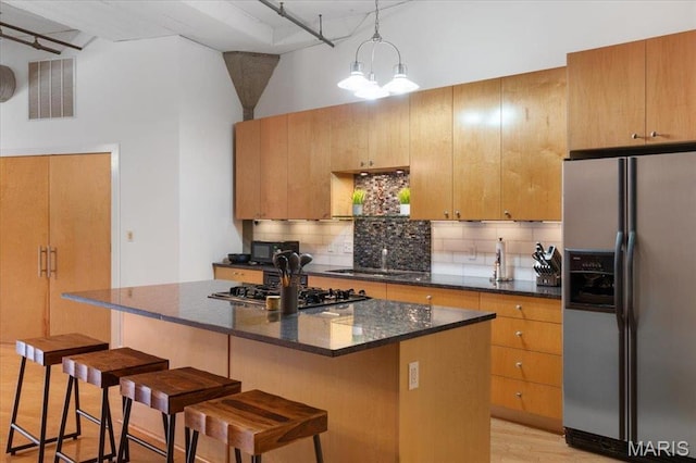 1619 Washington Ave Unit 805, Saint Louis, MO 63103 - kitchen with stainless steel appliances, tasteful backsplash, a kitchen breakfast bar, and a kitchen island