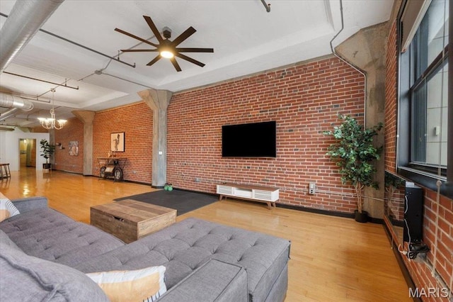 1619 Washington Ave Unit 805, Saint Louis, MO 63103 - living area with brick wall, ceiling fan, wood finished floors, a chandelier, and a raised ceiling