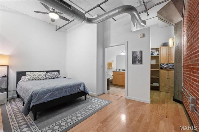 1619 Washington Ave Unit 805, Saint Louis, MO 63103 - bedroom featuring a high ceiling, light wood-style floors, brick wall, and ensuite bathroom