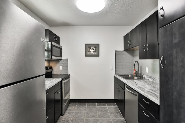 9154 Eager Rd, Saint Louis, MO 63144 - kitchen with appliances with stainless steel finishes, a sink, dark cabinetry, light countertops, and a textured ceiling