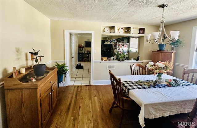 125 Hull Ave, Saint Louis, MO 63119 - dining space featuring dark wood-style flooring, a textured ceiling, and a chandelier