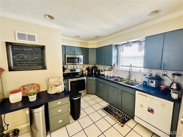125 Hull Ave, Saint Louis, MO 63119 - kitchen featuring stainless steel appliances, a sink, dark countertops, a textured ceiling, and backsplash