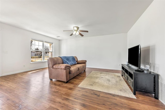 living room featuring ceiling fan, hardwood / wood-style flooring, and baseboards