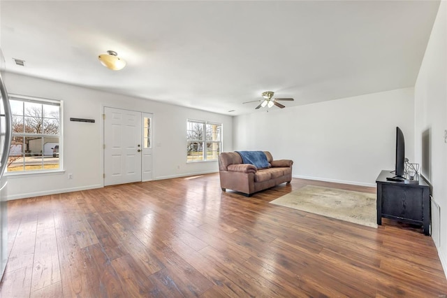 living room featuring hardwood / wood-style floors, ceiling fan, and baseboards