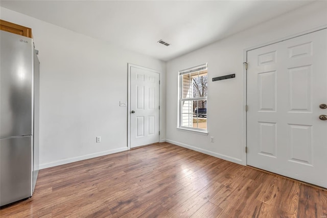 foyer featuring wood finished floors and baseboards