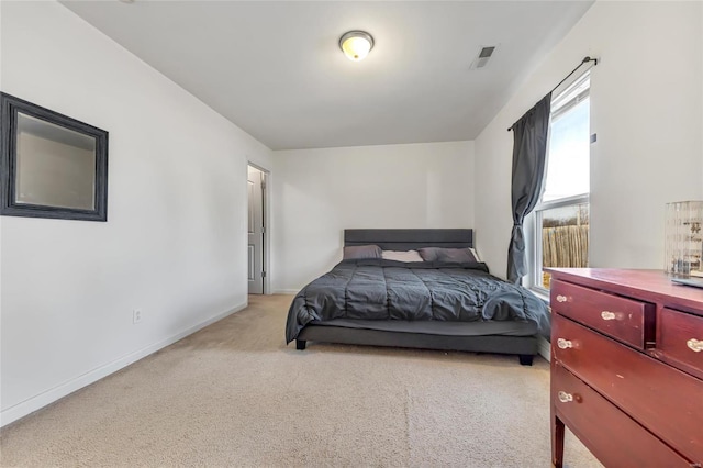 bedroom with light colored carpet and baseboards