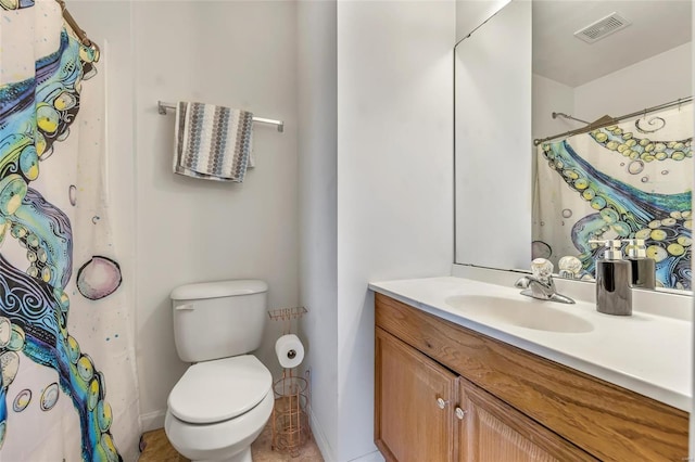 bathroom featuring toilet, vanity, baseboards, and curtained shower