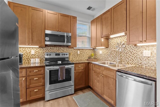 2005 Lynch St Unit C, Saint Louis, MO 63118 - kitchen with stainless steel appliances, a sink, light wood-style floors, and tasteful backsplash