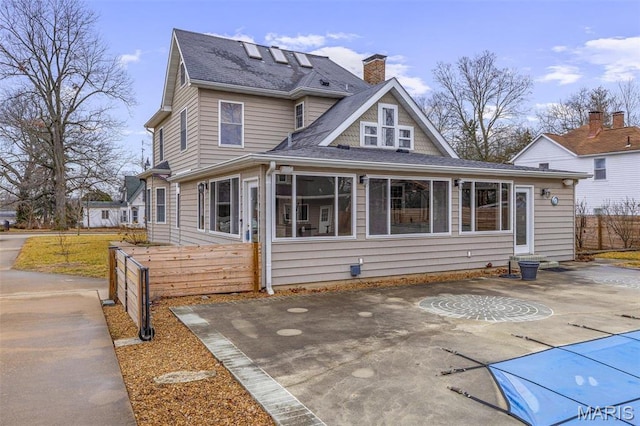 616 W Columbia St, Farmington, MO 63640 - rear view of house with a chimney, roof with shingles, a patio, and a sunroom