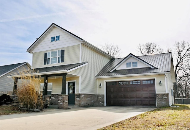 view of front of house featuring brick siding, covered porch, concrete driveway, an attached garage, and metal roof