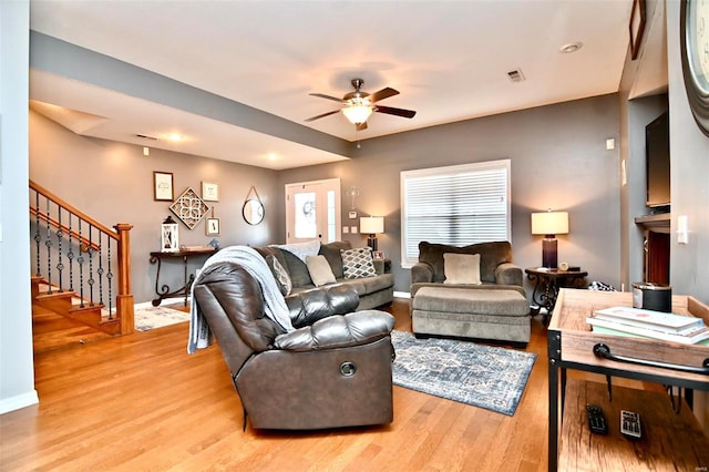 living area featuring ceiling fan, stairs, light wood-style floors, baseboards, and recessed lighting