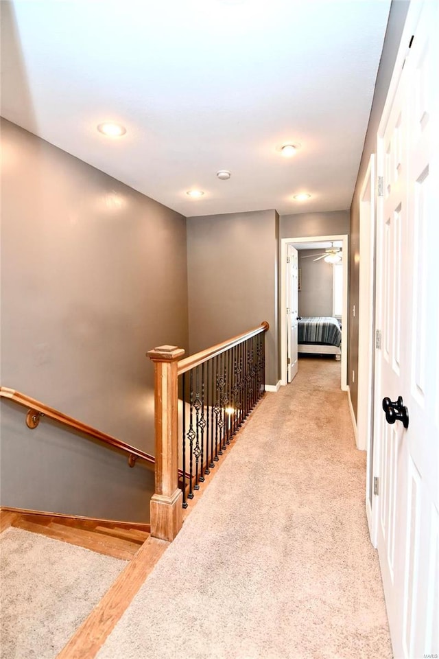 hallway featuring an upstairs landing, recessed lighting, and baseboards