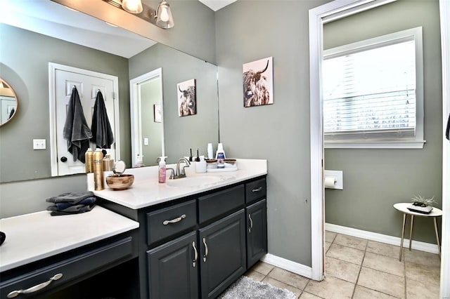 bathroom with tile patterned floors, vanity, and baseboards