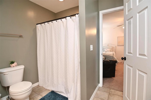 bathroom with tile patterned flooring, toilet, baseboards, and a shower with curtain