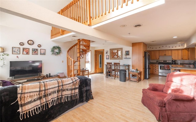 20020 Buffer Ln, Waynesville, MO 65583 - living room featuring stairs, light wood finished floors, and a towering ceiling