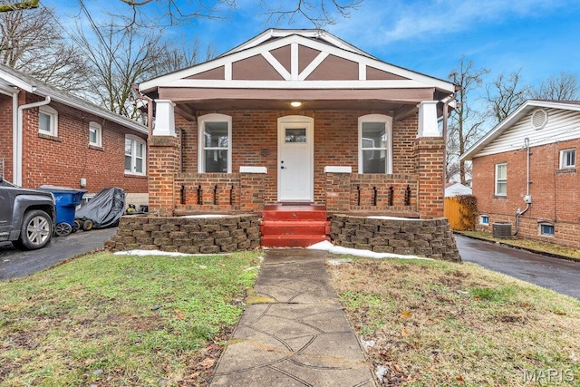 8806 Argyle Ave, Overland, MO 63114 - view of front of home with a porch, brick siding, and central AC unit