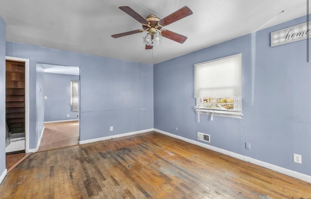 spare room with a ceiling fan, hardwood / wood-style flooring, and baseboards