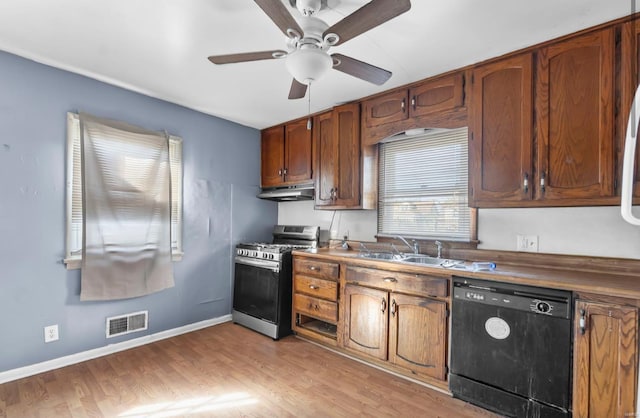 kitchen featuring dishwasher, stainless steel gas range oven, a sink, under cabinet range hood, and ceiling fan
