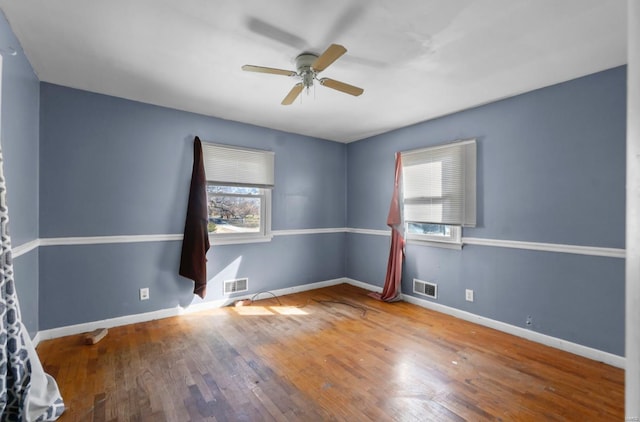 unfurnished room with ceiling fan, wood finished floors, and baseboards