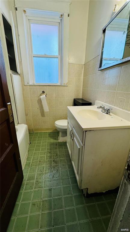 3449 Miami St, Saint Louis, MO 63118 - full bath with tile walls, vanity, wainscoting, toilet, and a tub