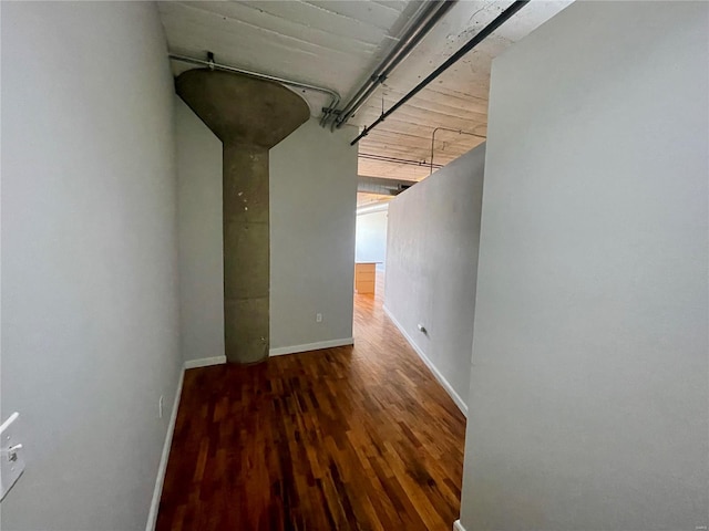 corridor featuring wood finished floors and baseboards
