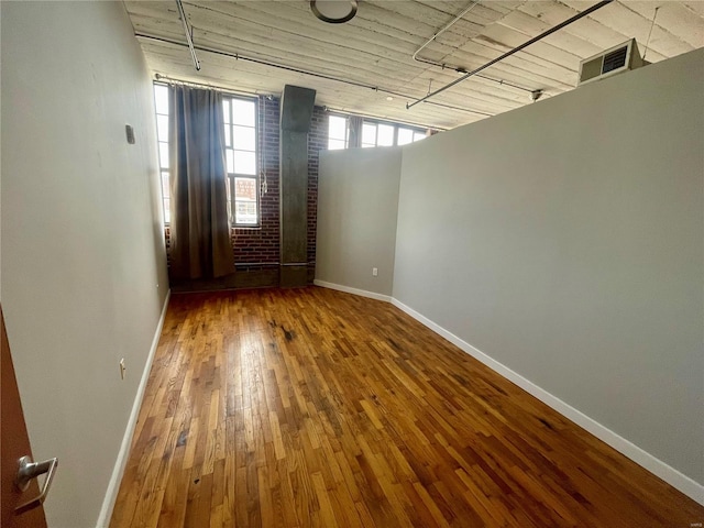 unfurnished room featuring hardwood / wood-style flooring and baseboards