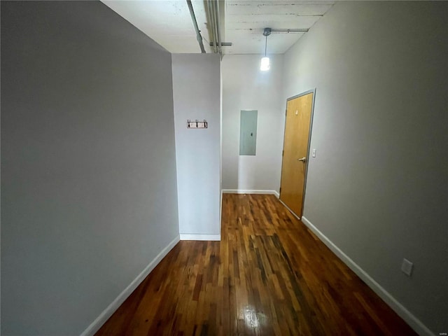 hallway with baseboards, dark wood-style floors, and electric panel