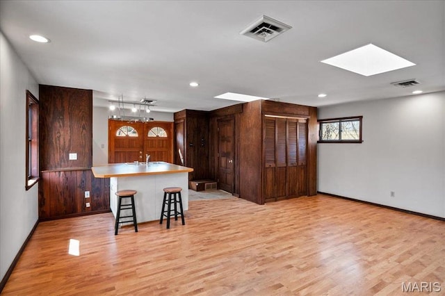2013 Lily Ave, Saint Louis, MO 63122 - kitchen featuring light wood finished floors, a skylight, a kitchen breakfast bar, recessed lighting, and an island with sink