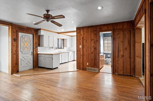 2013 Lily Ave, Saint Louis, MO 63122 - kitchen featuring a ceiling fan, wood walls, light wood-type flooring, dishwasher, and light countertops