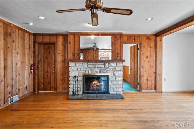 2013 Lily Ave, Saint Louis, MO 63122 - unfurnished living room with a ceiling fan, wooden walls, a stone fireplace, wood finished floors, and recessed lighting