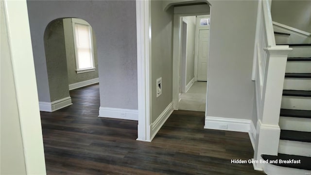 6522 Bartmer, University City, MO 63130 - corridor featuring arched walkways, dark wood finished floors, baseboards, a textured wall, and stairs
