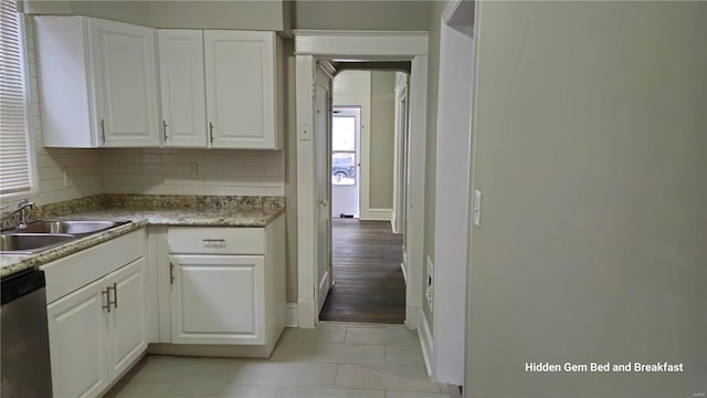 6522 Bartmer, University City, MO 63130 - kitchen featuring a sink, dishwasher, baseboards, white cabinetry, and light tile patterned floors