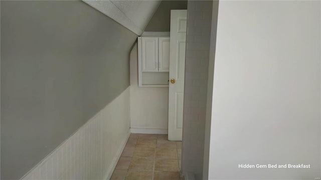6522 Bartmer, University City, MO 63130 - hallway featuring vaulted ceiling, light tile patterned flooring, and baseboards