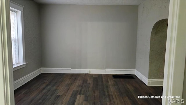 6522 Bartmer, University City, MO 63130 - empty room featuring plenty of natural light, dark wood-style floors, and a textured wall