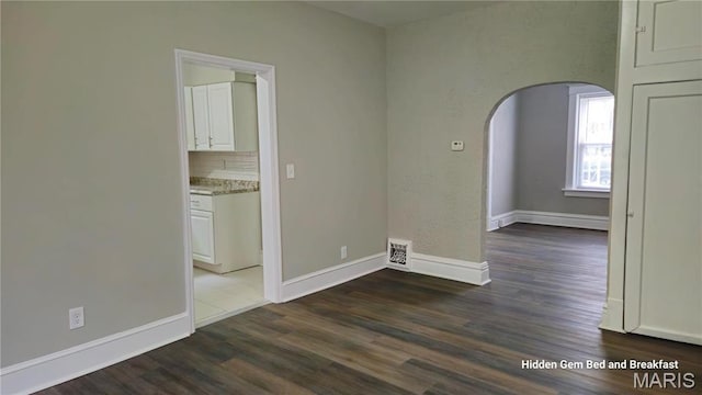 6522 Bartmer, University City, MO 63130 - spare room with arched walkways and wood finished floors
