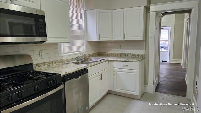 6522 Bartmer, University City, MO 63130 - kitchen with appliances with stainless steel finishes, light countertops, decorative backsplash, and white cabinetry