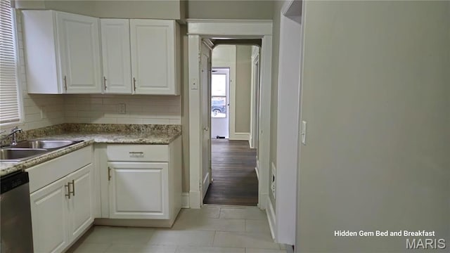 6522 Bartmer, University City, MO 63130 - kitchen with dishwasher, white cabinetry, light tile patterned flooring, arched walkways, and light countertops