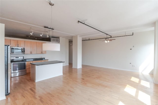 kitchen with stainless steel appliances, light brown cabinetry, ceiling fan, dark countertops, and light wood-style flooring