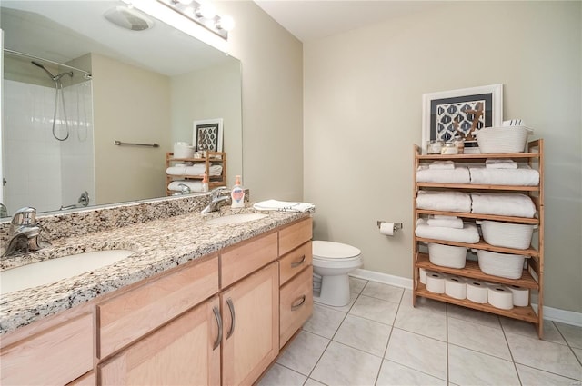bathroom with toilet, tile patterned flooring, baseboards, a shower, and double vanity
