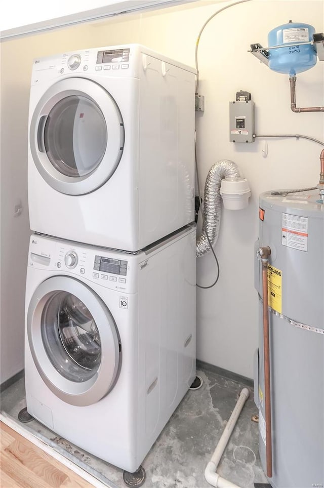 laundry area featuring water heater and stacked washer / drying machine