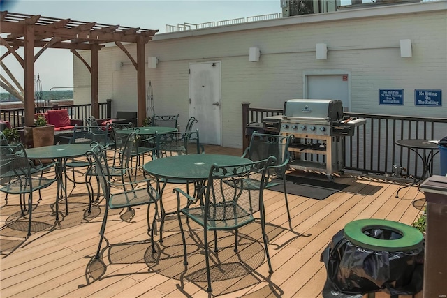 deck featuring grilling area, outdoor dining area, and a pergola