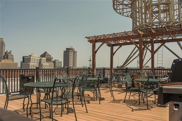 deck featuring a view of skyline, a pergola, and outdoor dining space